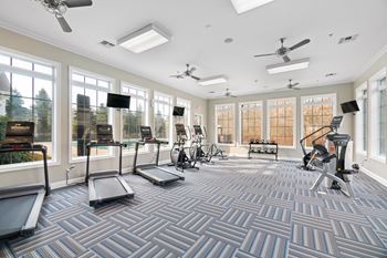 A spacious gym with treadmills, exercise bikes, and other equipment.